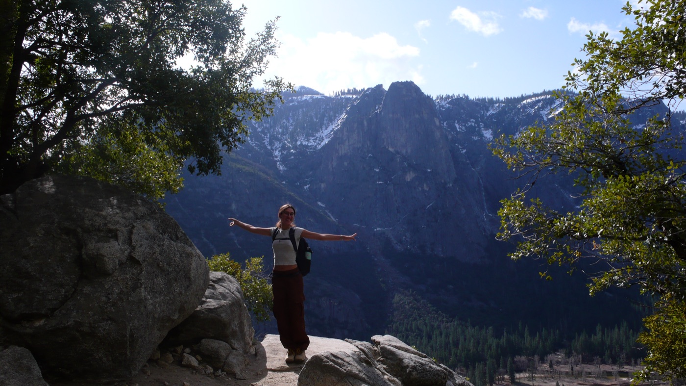 Arms out on a rock ledge in Yosemite valley
